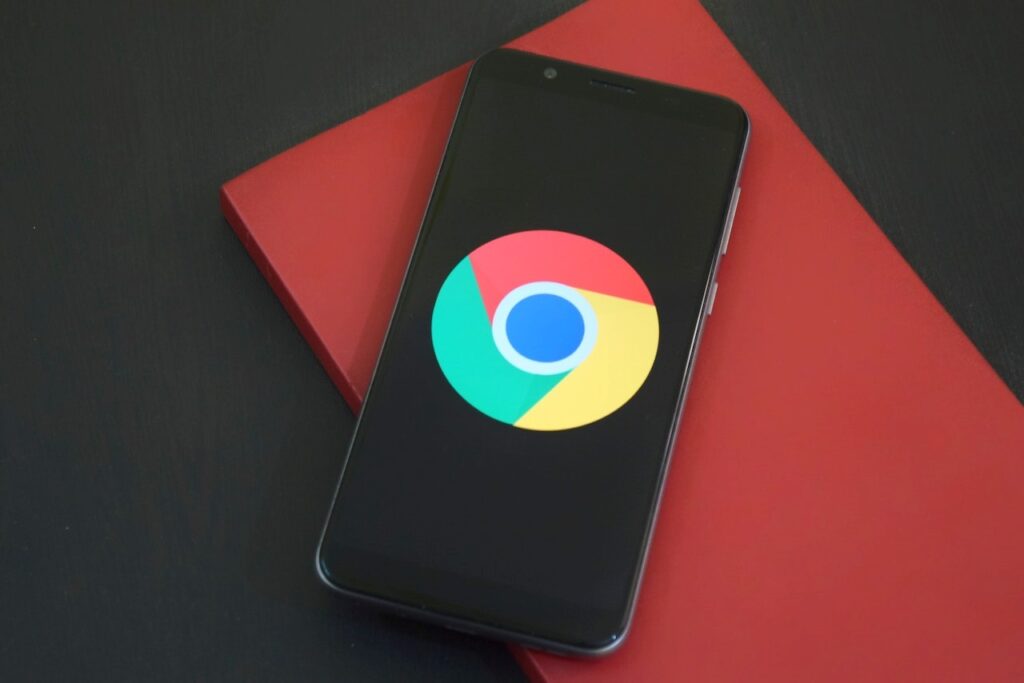 Há um celular em uma mesa com a imagem do navegador Google Chrome.
